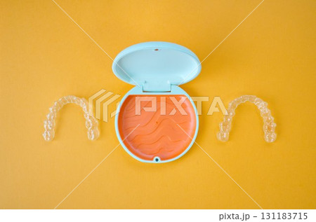 歯科矯正用のアライナーが入っているオレンジ色と白色のケース 歯科矯正用のアライナーが入っているオレンジ色と白色のケース 131183715