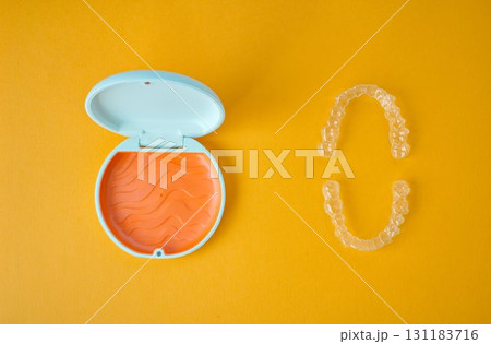 歯科矯正用のアライナーが入っているオレンジ色と白色のケース 131183716