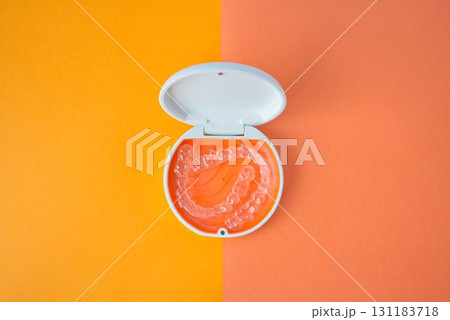 歯科矯正用のアライナーが入っているオレンジ色と白色のケース 131183718