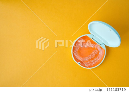 歯科矯正用のアライナーが入っているオレンジ色と白色のケース 131183719