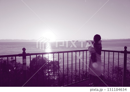 駿河湾の海の夕陽と一人旅女性のシルエット 131184634