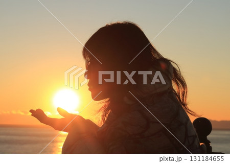 夕日を掌に載せ唇を近づける女性 夕日を掌に載せ唇を近づける女性 131184655