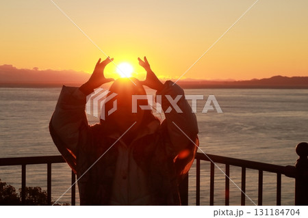駿河湾の海の夕陽と一人旅女性のシルエット 駿河湾の海の夕陽と一人旅女性のシルエット 131184704