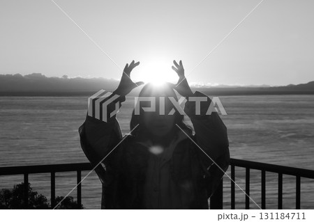 駿河湾の海の夕陽と一人旅女性のシルエット 駿河湾の海の夕陽と一人旅女性のシルエット 131184711