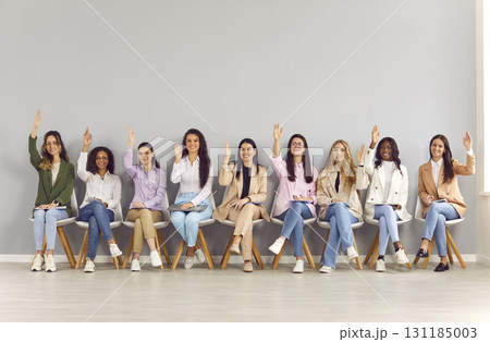 Group of happy women raising their hands to ask questions at business conference Group of happy women raising their hands to ask questions at business conference 131185003
