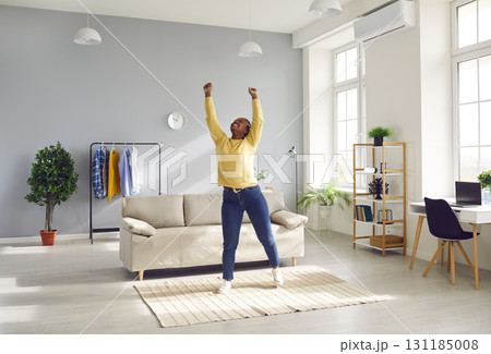 Happy woman enjoying leisure time at home, stretching and charging with positive energy Happy woman enjoying leisure time at home, stretching and charging with positive energy 131185008