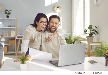 Happy young family couple using their laptop computer and paying their bills online 131185035