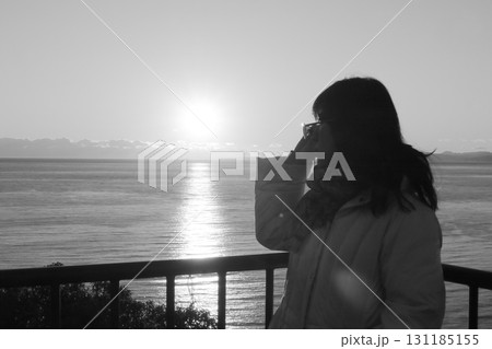 駿河湾の海の夕陽と一人旅女性のシルエット 駿河湾の海の夕陽と一人旅女性のシルエット 131185155