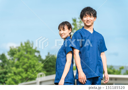 病院・施設の前にいるスクラブを着た医療従事者の男女スタッフ（作業療法士・看護師） 131185520