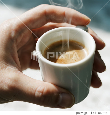 Hand Holding a Steaming Cup of Espresso Hand Holding a Steaming Cup of Espresso 131186986