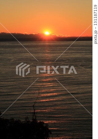 海の夕陽伊豆半島から見る駿河湾にオレンジ色に染まる太陽の光 131187119