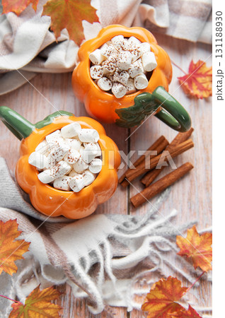 Pumpkin mugs with hot chocolate and marshmallows for autumn comfort Pumpkin mugs with hot chocolate and marshmallows for autumn comfort 131188930