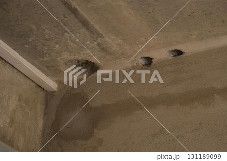 Holes in cement ceiling for sewer pipes in construction in apartment building. 131189099