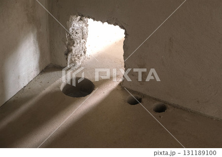 Holes in cement floor for sewer pipes in construction in apartment building. 131189100