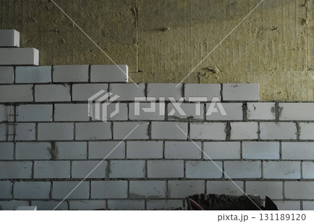 Construction works of laying bricks blocks creating walls in building. 131189120