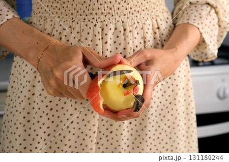 Woman peeling apple cooking food dish on kitchen at home, hands close-up. Woman peeling apple cooking food dish on kitchen at home, hands close-up. 131189244