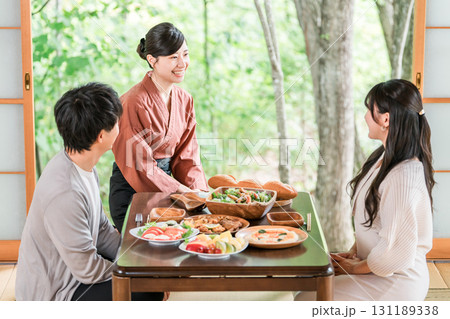 温泉旅館の客室で料理の説明をする旅館スタッフ・仲居さんの女性 131189338