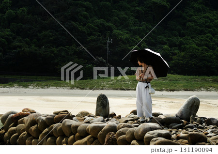 ＜素材＞秋の海を眺める日傘の女性 131190094