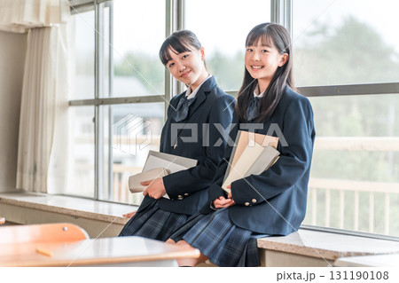 学校の教室で会話する小学生,中学生の女子生徒 131190108