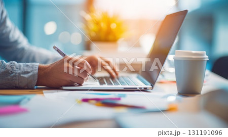 A close-up of a person's hands as they type on a laptop keyboard and take notes, symbolizing productive work, business, online communication, or distance education A close-up of a person's hands as they type on a laptop keyboard and take notes, symbolizing productive work, business, online communication, or distance education 131191096