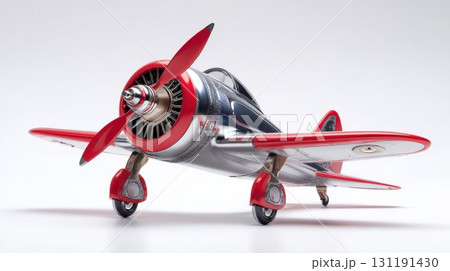 A stylized, chrome and red model airplane with a propeller is shown on a clean, isolated background 131191430