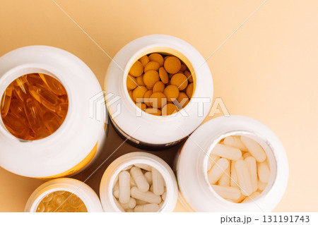 Open vitamin bottles with tablets and capsules top view Open vitamin bottles with tablets and capsules top view 131191743