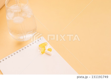 Supplements on notebook with iced water and copy space 131191749