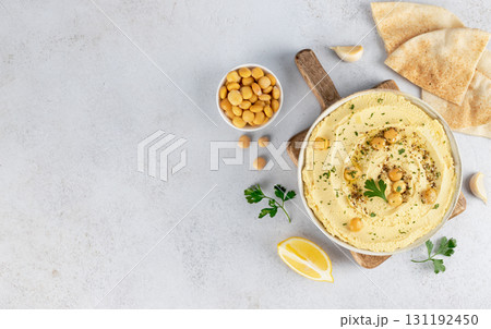 Lupini bean hummus with olive oil, herbs and pita on white background. Top view. Copy space. Vegan food. Lupini bean hummus with olive oil, herbs and pita on white background. Top view. Copy space. Vegan food. 131192450