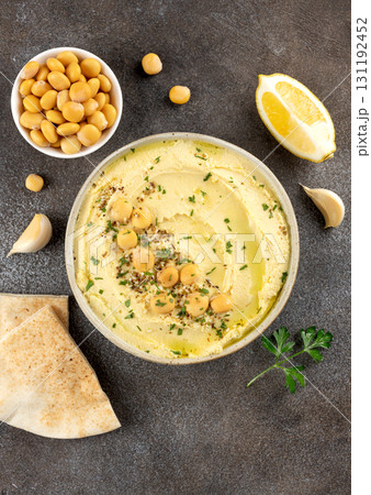 Lupini bean hummus with olive oil, herbs and pita bread on dark background. Vegetarian food.Top view Lupini bean hummus with olive oil, herbs and pita bread on dark background. Vegetarian food.Top view 131192452