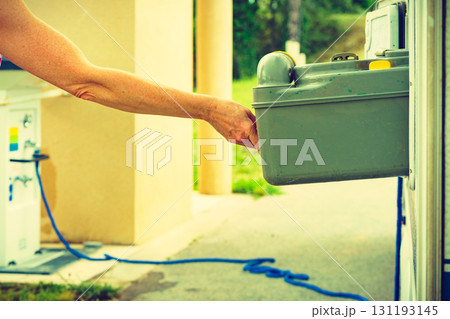 Person serving caravan, tank toilet cassette in dump station. 131193145