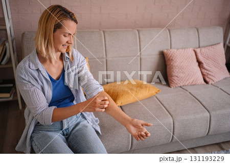 Woman scratching her arm suffering from strong allergy Woman scratching her arm suffering from strong allergy 131193229