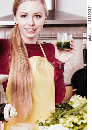 Woman in kitchen holding vegetable juice 131193344