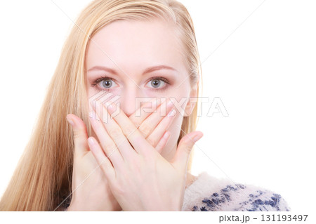 Shocked young woman covering mouth with hand Shocked young woman covering mouth with hand 131193497