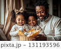 Man and two children are sitting on a couch, smiling 131193596