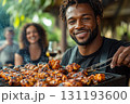 Man is grilling chicken on a barbecue grill 131193600