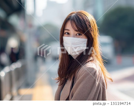 街角で立ち止まるマスク姿の女性 131194714