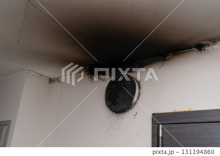 Burnt out LED lamp. A lampshade lamp on the wall after a fire. Spontaneous combustion and fire in a residential building. 131194860