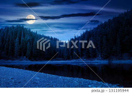 scenic landscape by the lake in autumn forest at night. beautiful scenery of national park in fall season in full moon light. colorful environment reflection in the pond. outdoor adventure in woods 131195944