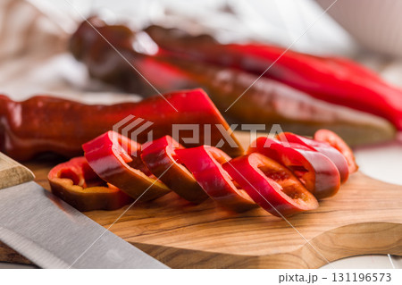 Corno di Toro Rosso pepper. Sliced red paprika vegetable on cutting board. 131196573