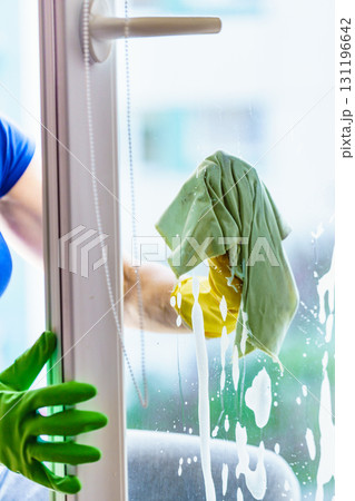 Woman cleaning window at home 131196642