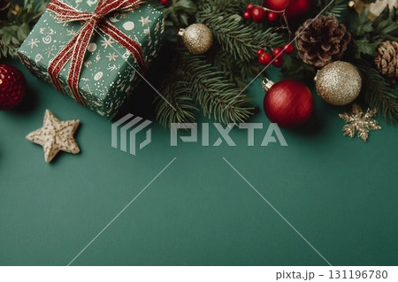 Merry Christmas! Stylish christmas border with festive decorations, confetti,gift, fir branches on green background. Christmas flat lay. Seasons greetings card template, space for text 131196780