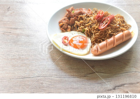 fried instant noodles in mala sichuan sauce topping egg and chicken on plate 131196810