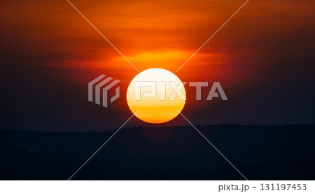 Sun eclipse shining brightly over the horizon during a stunning sunset 131197453