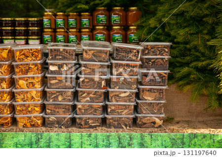 Dried mushrooms in plastic containers at a Christmas rural fair - chanterelles and porcini mushrooms. Forestry 131197640