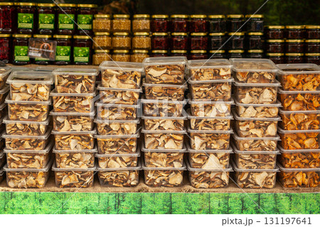 Dried mushrooms in plastic containers at a Christmas rural fair - chanterelles and porcini mushrooms. Forestry 131197641