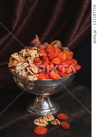 Vase with dried fruit and nuts. Still life with Ancient East metallic crockery Vase with dried fruit and nuts. Still life with Ancient East metallic crockery 131197719