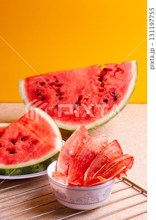 Winter supplies: slices of dried watermelon with fresh pieces on yellow background Winter supplies: slices of dried watermelon with fresh pieces on yellow background 131197755