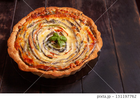 Vegetable Spiral tart with zucchini, eggplant, carrot on wooden background Vegetable Spiral tart with zucchini, eggplant, carrot on wooden background 131197762