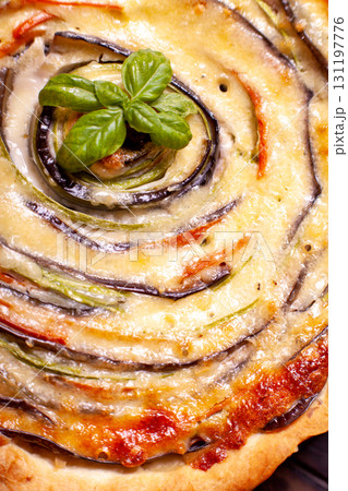 Background of Vegetable Spiral tart with zucchini, eggplant, carrot with a sprig of basil, close up macro shoot 131197776