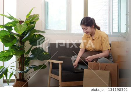 Online Shopping. Young woman browsing laptop surrounded by shopping bags. Online Shopping. Young woman browsing laptop surrounded by shopping bags. 131198592
